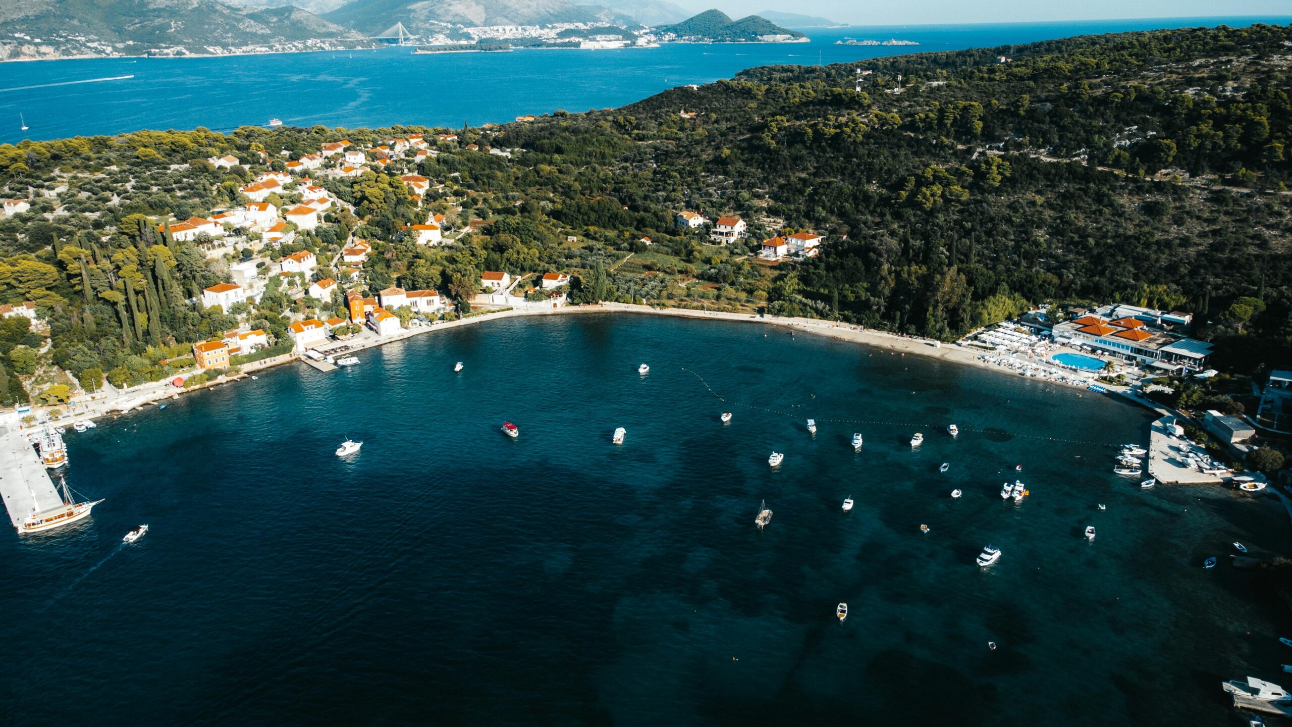 Eine atemberaubende Luftaufnahme der KÃ¼ste der Insel KoloÄep mit Booten und Ã¼ppigem GrÃ¼n in Kroatien.