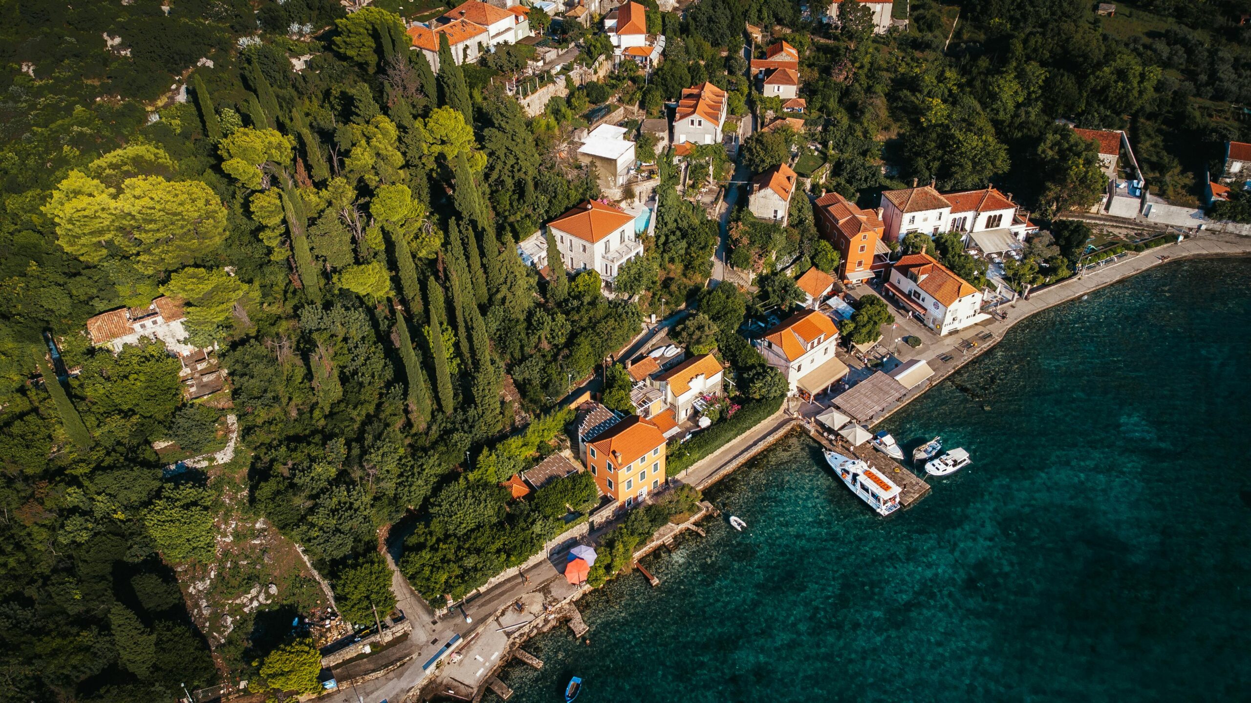 Eine atemberaubende Luftaufnahme der KÃ¼ste der Insel KoloÄep mit Ã¼ppigem GrÃ¼n und klarem blauen Wasser.