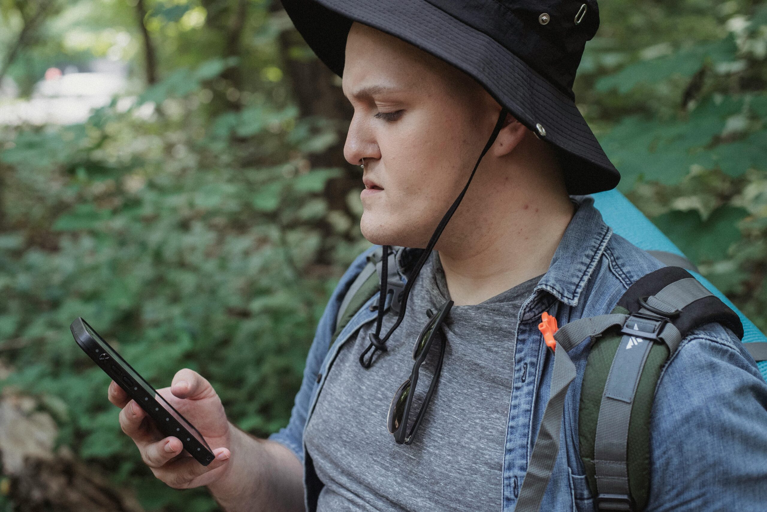 Fokussierter Junger MÃ¤nnlicher Rucksacktourist, Der Standort Auf Smartphone In Der Natur PrÃ¼ft