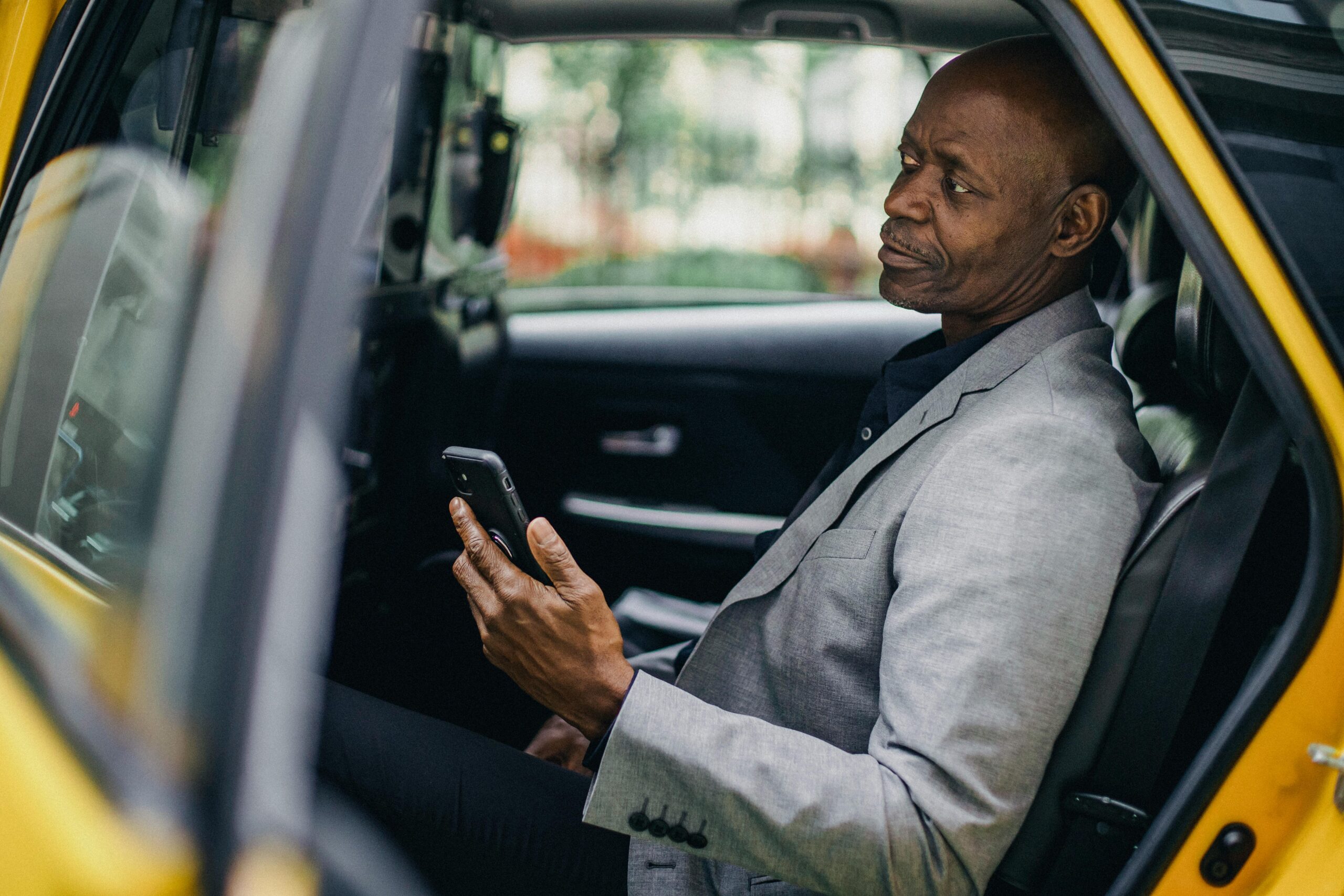 Kontemplativer Schwarzer GeschÃ¤ftsmann, Der Smartphone Im Taxi Verwendet